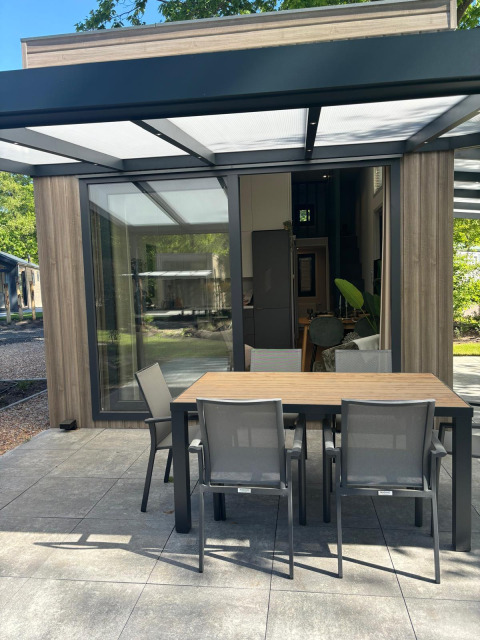 Moderne Terrasse mit Essbereich am Reeëndal Lodge im Veluwepark de Bosgraaf, Niederlande.