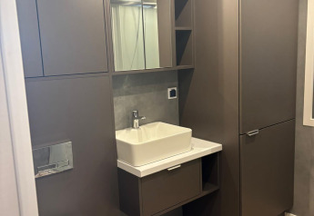 Modern bathroom at Reeëndal Lodge, Veluwepark de Bosgraaf, Netherlands, featuring grey cabinets and sink.