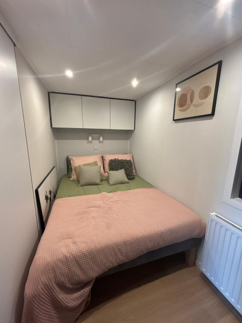 Modernes Schlafzimmer im Reeëndal Lodge, Veluwepark de Bosgraaf, Niederlande, mit Doppelbett.