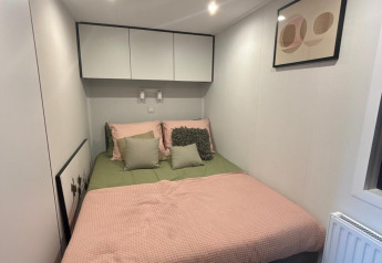 Modern lodge bedroom at Reeëndal Lodge, Veluwepark de Bosgraaf, Netherlands, featuring a double bed.