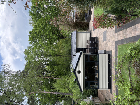 Et hyggeligt Veluwe Chalet i Veluwepark de Bosgraaf, Holland, omgivet af frodige træer og have.