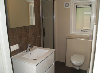 Moderne badkamer in Velthorst Hottub, EuroParcs Ruinen, Nederland, met douche, wastafel en hangtoilet.