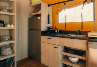 Cucina nella tenda safari Ranger Lodge presso Holiday Park Sallandshoeve, Paesi Bassi, in stile rustico.
