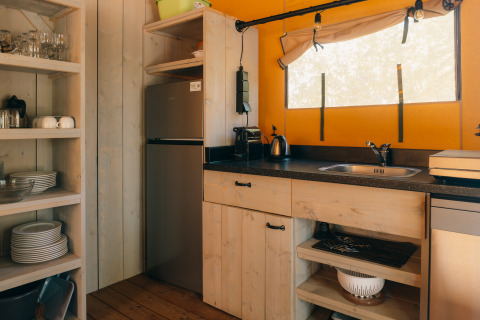 Kitchen inside the Ranger Lodge safari tent at Holiday Park Sallandshoeve in the Netherlands, rustic style.