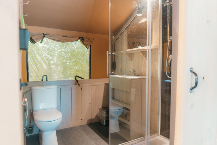 Salle de bain avec toilettes, lavabo et douche dans une tente safari au Ranger Lodge, Sallandshoeve, Pays-Bas.