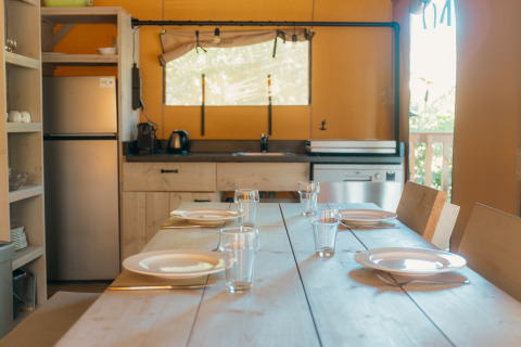 Bright kitchen inside the Ranger Lodge safari tent at Holiday Park Sallandshoeve, set for dining.