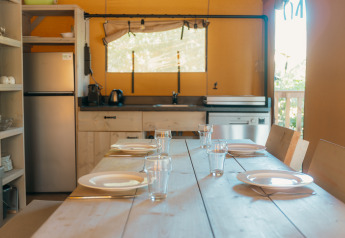 Heldere keuken binnen de safaritent Ranger Lodge bij Holiday Park Sallandshoeve, tafel gedekt.