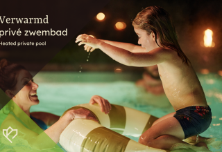 Madre e hija disfrutando de una piscina privada climatizada por la noche en un lodge, con luces suaves.
