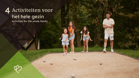 Family enjoys playing an outdoor game together on a sunny day near a lodge, surrounded by green nature.