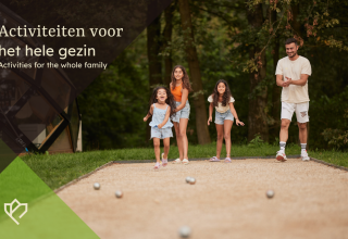 Gezin speelt samen een buitenspel bij een lodge, genietend van een zonnige dag in het groen.
