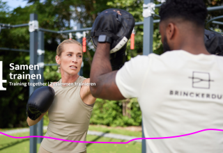 Twee mensen trainen samen buiten met bokshandschoenen bij de glampinglocatie Unbrick One | Sauna.