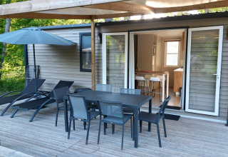 Terraza de madera con comedor exterior y tumbonas en Mobilhome Toulouse, La Draille, Francia.