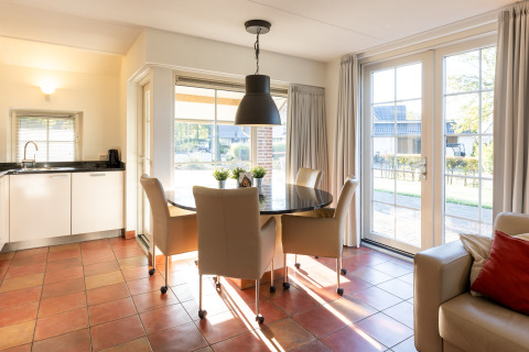 Cocina y comedor luminosos en Wellness Lodge XL, Hof van Salland, Países Bajos, con grandes ventanales.