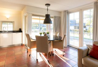 Cocina y comedor luminosos en Wellness Lodge XL, Hof van Salland, Países Bajos, con grandes ventanales.