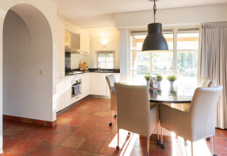 Cocina y comedor modernos en Wellness Lodge XL en Hof van Salland, Países Bajos, con mucha luz natural y ventanas grandes.