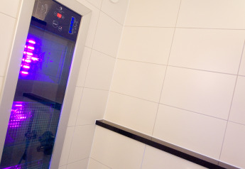 Doccia moderna con soffione a pioggia, pannello di controllo e luce LED viola in Wellness Lodge XL, Hof van Salland, Paesi Bassi.