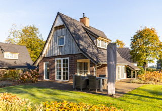 Wellness Lodge XL bij Hof van Salland in Nederland, charmant huisje met tuin, terras en najaarskleuren.