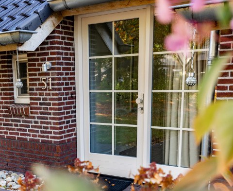 Eingang der Wellness Lodge XL im Hof van Salland, Niederlande, mit Glastür und Backsteinfassade.