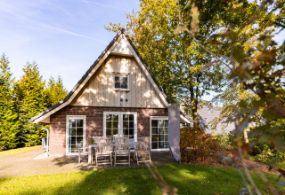 Wellness Lodge XL at Hof van Salland in the Netherlands, exterior view with garden furniture and trees.