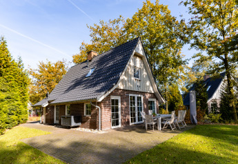 Lodge Wellness XL à Hof van Salland, Pays-Bas, petite maison moderne avec terrasse et jardin arboré.