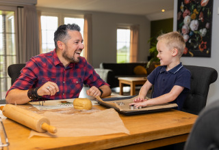 Padre e hijo hornean galletas juntos en Wellness Lodge XL en Hof van Salland, Países Bajos.