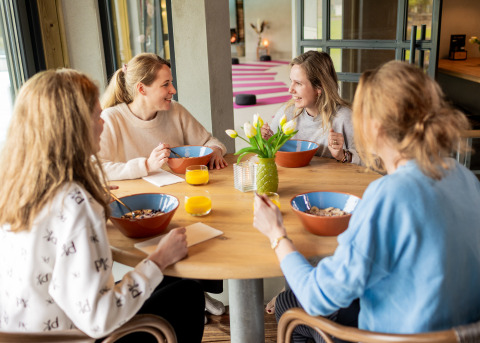 Quattro donne fanno colazione insieme nella Wellness Lodge XL presso Hof van Salland, Paesi Bassi, luminosa.