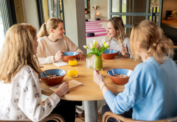 Quatre femmes prennent le petit-déjeuner ensemble à la Wellness Lodge XL au Hof van Salland, Pays-Bas, ensoleillé.