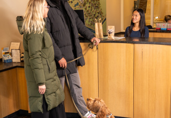 Pareja con perro realizando el check-in en la recepción de Wellness Lodge XL, Hof van Salland, Países Bajos.