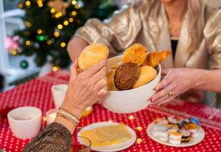 Desayuno navideño en Wellness Lodge XL, Hof van Salland, Países Bajos, con panecillos y mesa festiva.