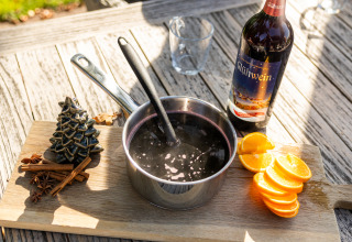 Preparación de vino caliente con naranjas, especias y botella en Wellness Lodge XL, Hof van Salland, Países Bajos.