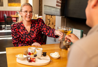 Dos personas disfrutan postre y bebidas en un restaurante de Wellness Lodge XL, Hof van Salland, Países Bajos.