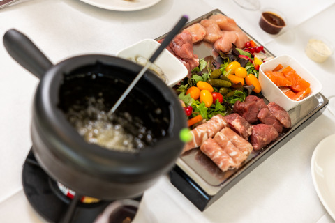 Bandeja de fondue con carne cruda, verduras y salsas en Wellness Lodge XL, Hof van Salland, Países Bajos.