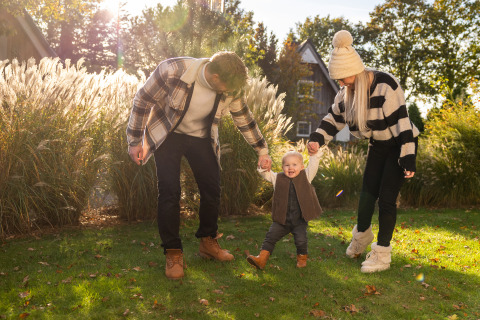 Familia caminando de la mano en el jardín de Wellness Lodge XL, Hof van Salland, Países Bajos, en un día soleado.