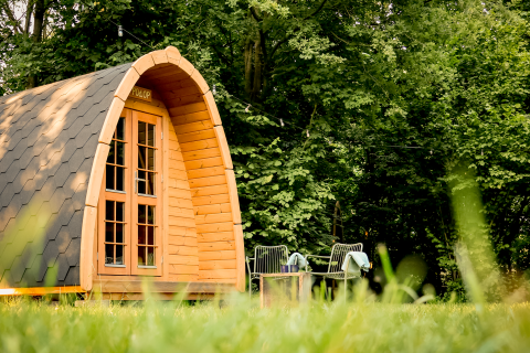 Pod Duo Panorama en RØSTIG Dorst, Países Bajos, rodeado de árboles y césped con asientos al aire libre.
