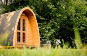 Duo Panorama pod at RØSTIG Dorst, Netherlands, nestled in greenery with outdoor seating and lush trees.