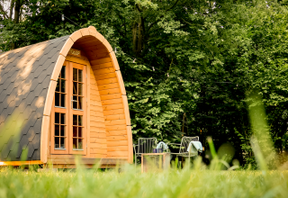 Pod Duo Panorama en RØSTIG Dorst, Países Bajos, rodeado de árboles y césped con asientos al aire libre.
