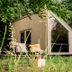 Moderne tiny house Luxe & Lazy Lodge gemt blandt frodige træer hos RØSTIG Dorst, Holland, med hyggelig udendørs siddeplads.
