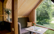 Indvendigt billede af en hyggelig tiny house, Luxe & Lazy Lodge, med stort vindue og udsigt til naturen.