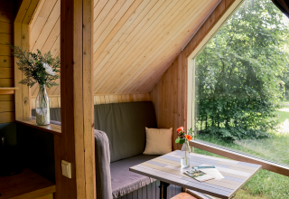 Cozy interior of Luxe & Lazy Lodge tiny house at RØSTIG Dorst, Netherlands, featuring a large window view.