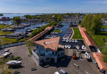 Vue aérienne de Safari tent Heeg à Marina Heeg aux Pays-Bas avec quais, bateaux et espaces verts.