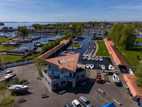 Vue aérienne de Safari tent Heeg à Marina Heeg aux Pays-Bas avec quais, bateaux et espaces verts.