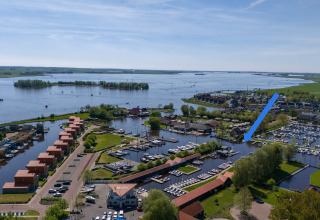 Aerial view of Marina Heeg with a blue arrow marking the safari tent by the lake, scenic Dutch landscape.