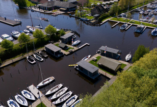 Vista aérea de la tienda safari Heeg en Marina Heeg, Países Bajos, rodeada de barcos y canales.