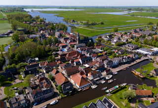 Luchtbeeld van Safari tent Heeg bij Marina Heeg in Nederland, omgeven door kanalen en weiden.