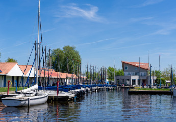 Både fortøjet ved Marina Heeg i Nederlandene, under klar blå himmel nær Safari telt Heeg.