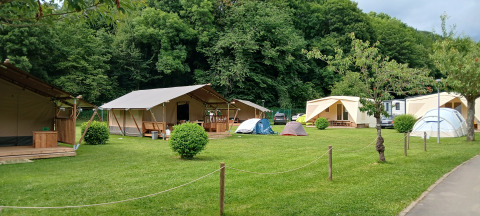 Tende safari e tende da campeggio su prato al Camping Floreal La Roche-en-Ardenne in Belgio.