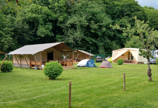 Safari-telte og campingtelte på grøn plæne ved Camping Floreal La Roche-en-Ardenne i Belgien.