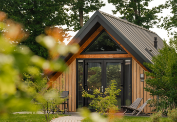 Tiny house Wellness Lodge con fachada de madera y grandes ventanales en Holiday Park De IJsvogel, Países Bajos.