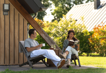 Zwei Personen entspannen vor der Wellness Lodge im Holiday Park De IJsvogel in den Niederlanden im Freien.