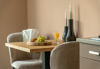 Piccolo tavolo da pranzo con uva, succo e croissant in un angolo accogliente alla Wellness Lodge, Holiday Park De IJsvogel.